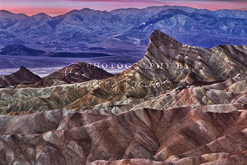 This photo was taken moments before sunrise from Zabriskie Piont Lookout, Death Valley National Park. The foreground of this scene shows the Badlands formations, Manly Beacon, Death Valley and the Panamint Range in the distance. The photo was captured with a Canon 1D Mark IV and a Canon 24-70mm L lens set to 70mm.