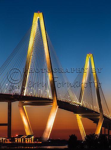 The Arthur Ravenel Bridge spans the Cooper River in South Carolina. The bridge is a cable-stayed suspension design with two tower that are each 575 feet tall. This modern structure connecting Charleston to Mount Pleasant has eight lanes of traffic and a shared bicycle-pedestrian path.
