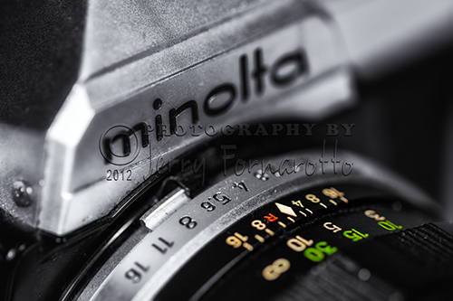 A closeup photo of a Minolta XG7. The first model of this series to be introduced in 1977. Minolta is best known for making the first autofocus 35mm SLR camera. Minolta is an acronym for “Mechanism, Instruments, Optics, and Lenses by Tashima.”