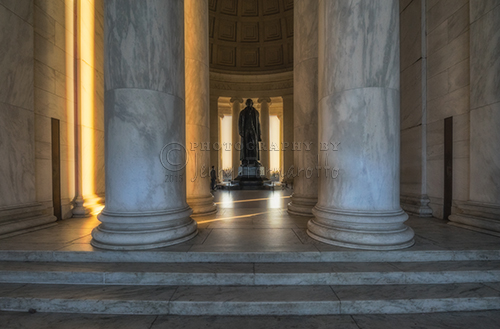 The interior of the Jefferson Memorial illuminated with golden light.