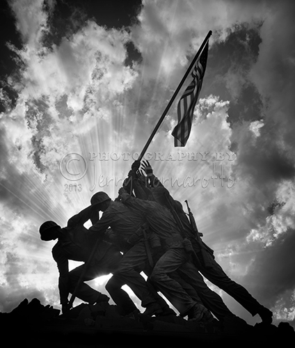 A sunset black and white photo of the Marine Corps War Memorial. This memorial is sometimes called the Iwo Jima Memorial.