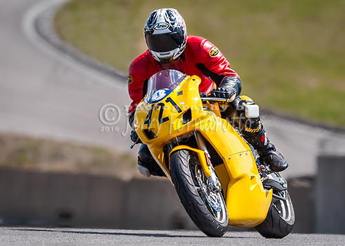 A yellow Ducati Super motorcycle racing.