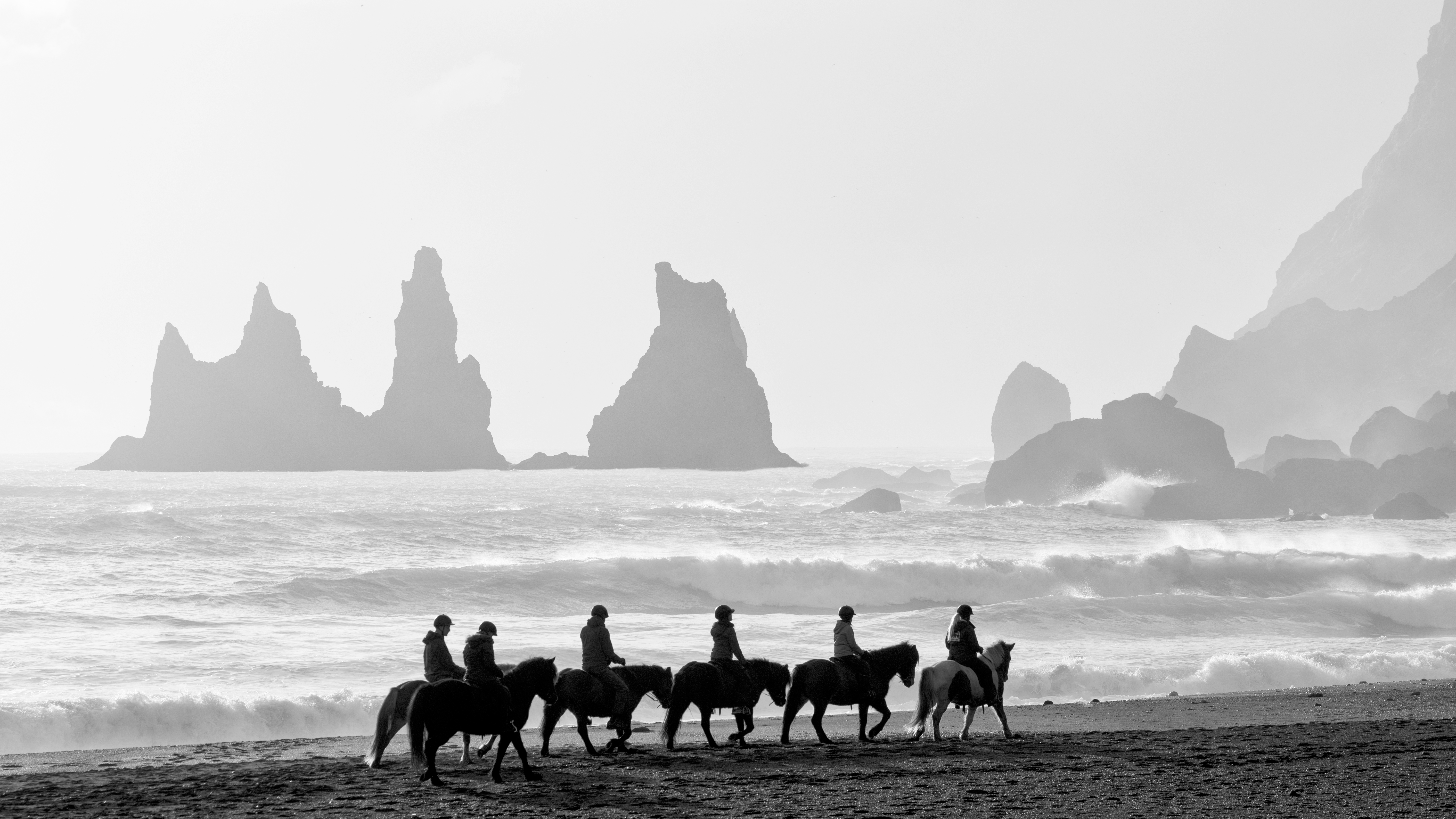 A group of riders at Reynisfjara Beach. This beach is a beautiful black sand beach under Reynisfjall mountain, not far from the city of Vik, Iceland.