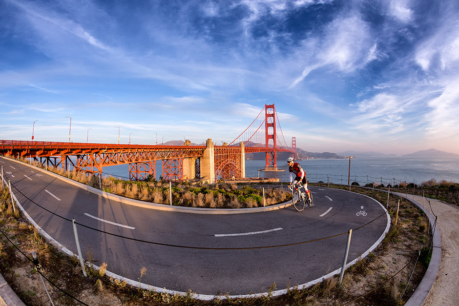 Cyclist on the bike path approach to Golden Gate Bridge. In the background are the Marin Headlands.